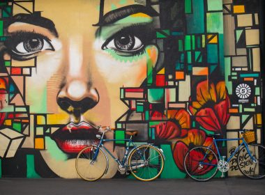 two blue cruiser bicycles on graffiti wall